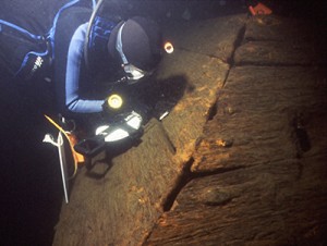 Underwater archaeologist Joseph W. Zarzynski makes a measurement of the starboard view hold on the 1758 Land Tortoise radeau shipwreck, a British warship from the French & Indian War.