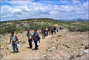 A group of immigrants attempting the trek across the US-Mexican border.  As you can see, they are carrying plastic jugs of water to stay hydrated, although the water likely is not enough.