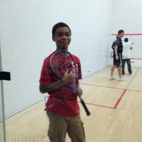 Elijah demonstrates how to use a squash racket
