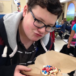 David shows off his cookie. David is a 9th grader at PHS who comes back to VAST to help out