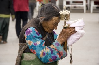 Elderly Tibetan Woman with Prayer Wheel and Recitation Beads